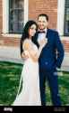 romantic-couple-in-love-celebrate-their-wedding-embrace-each-other-affectionately-have-happy-expressions-stand-outdoor-nice-young-wedding-couple-a-2AYW6CM