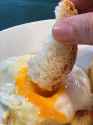 hand-dipping-bread-egg-food-drink-yolk-fried-close-view-378617408