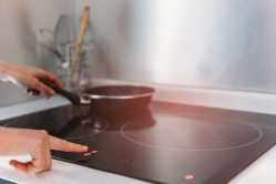 detail-of-female-hand-using-induction-stove-in-kitchen