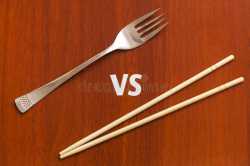 wooden-pairs-chopsticks-vs-fork-abstract-conceptual-image-table-74993924