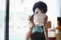 a-ramen-noodle-cafe-in-a-city-a-woman-seated-eating-ramen-noodle-soup-sipping-from-the-bowl-MINF04696