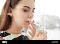 young-woman-lighting-cigarette-at-home-2BJFAHJ