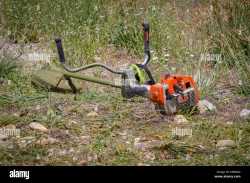 brush-cutter-cutting-weeds-in-a-garden-FAB4GD
