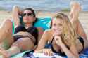 140774423-two-beautiful-women-sunbathing-on-the-beach