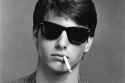 Greyscale-image-of-Tm-Cruise-wearing-black-80s-style-sunglasses-with-cigarette-hanging-out-his-mouth