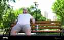 confident-fat-man-sitting-in-park-feels-happy-contented-with-life-self-love-2AN1EM4