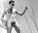 1960s nudist hanging on to the sailboat rigging
