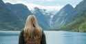 videoblocks-woman-standing-at-edge-of-lake-looking-at-view-of-mountain-camping-girl-in-scenic-landscape-enjoying-vacation-travel-adventure-nature-norway_b_pjidjox_thumbnail-full01