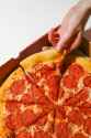 person taking a slice of pepperoni pizza