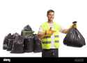 garbageman-holding-a-plastic-bag-in-front-of-a-bin-and-a-pile-of-bags-and-pointing-isolated-on-white-background-2G4N0HE