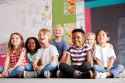 group-of-elementary-school-pupils-sitting-on-floor-in-classroom