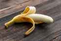 golden-half-peeled-banana-ready-eat-wooden-table-yellow-banana-without-peel_431724-13942_jpg