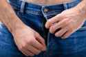 man-unzipping-the-blue-jeans