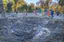 A man passes past a rocket crater at playground in city park in center Kyiv, Ukraine, Tuesday, Oct. 11, 2022.