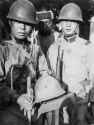 Japanese soldiers show off the helmet that saved the life of their comrade (rear) during the Battle of Beiping (Beijing)-Tianjin of the Second Sino-Japanese War.jpg