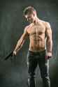 44094822-half-body-shot-of-a-handsome-athletic-man-with-no-shirt-holding-a-handgun-while-looking-to-the-left