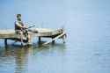 man-fishing-from-dock-over-lake-CAIF28570