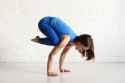 side-view-of-athletic-girl-in-blue-sportswear-doing-crow-pose