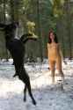 Naked-girl-playing-snowballs-with-dog-at-winter-forest-4