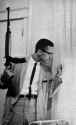 malcolm-x-with-a-rifle-peering-out-the-window-of-his-home-v0-ylv30mqjd72a1