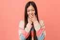 young-cool-chinese-woman-laughing-about-something-covering-mouth-with-hands_1187-29424