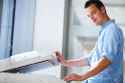 Handsome-young-man-using-a-copy-machine-shallow-DOF-color-toned-image-Stock-Photo