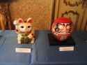 1024px-Maneki_neko_and_daruma_doll_by_txkun[1]