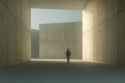 Businessman walking in concrete corridor