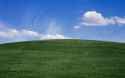 Blue sky and clouds above grassy hill