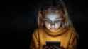 little-girl-in-yellow-sweater-looking-at-cell-phone-photo