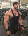 bradley-martyn-besides-dumbbell-rack-looking-at-himself-in-the-mirror